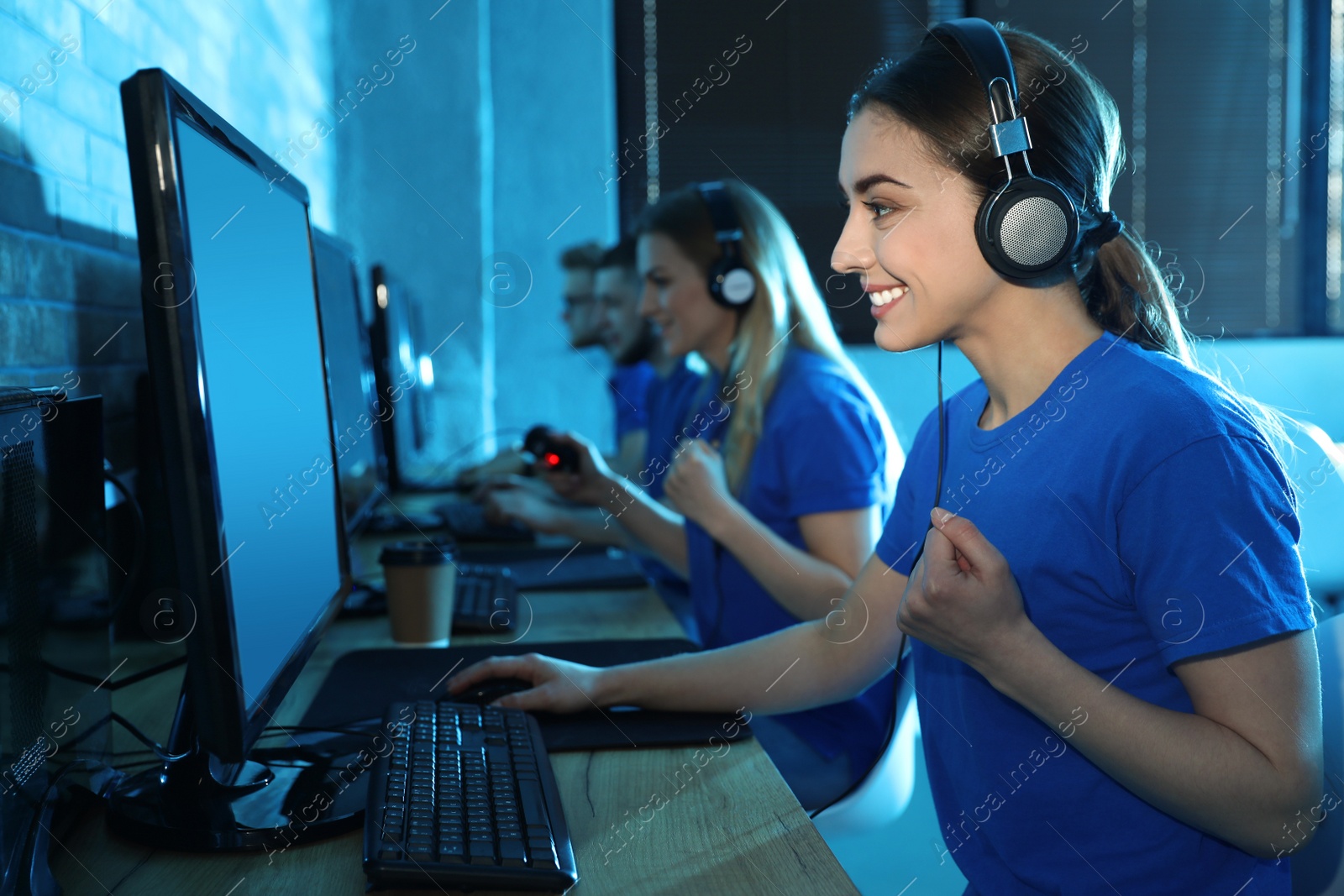 Photo of Group of people playing video games in internet cafe