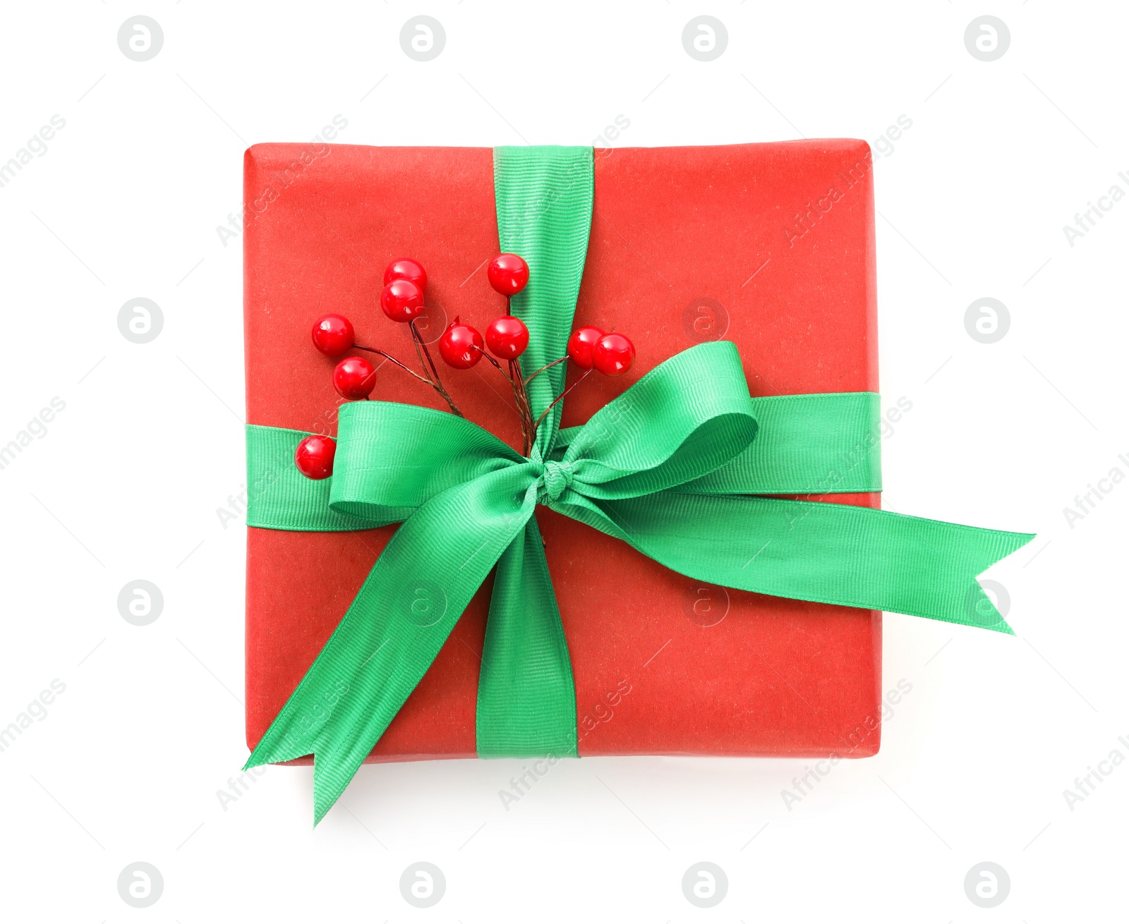 Photo of Christmas gift box decorated with green bow and berries isolated on white, top view