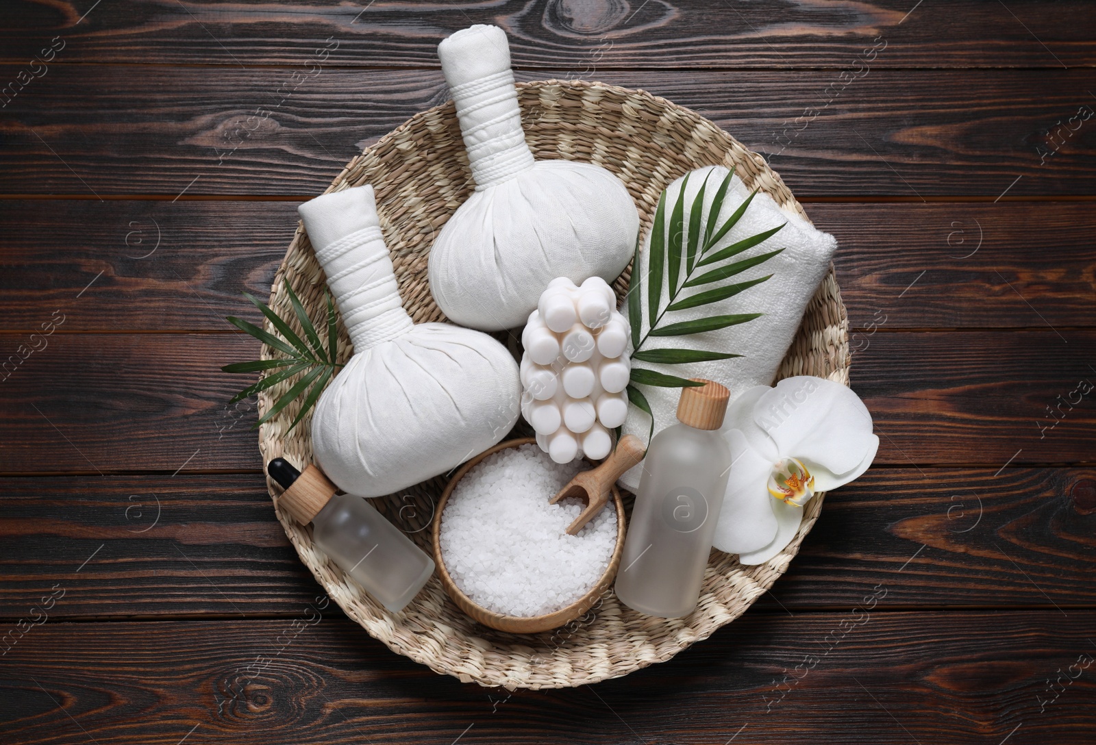 Photo of Composition of herbal bags and spa products on wooden table, top view