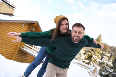 Lovely couple spending time together on snowy day. Winter vacation