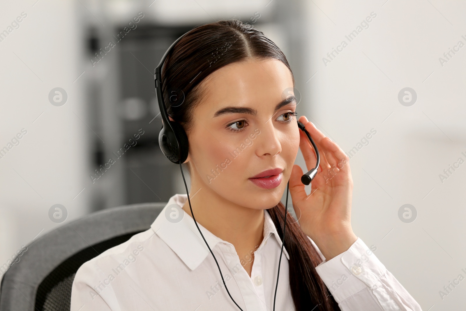 Photo of Hotline operator with headset working in office