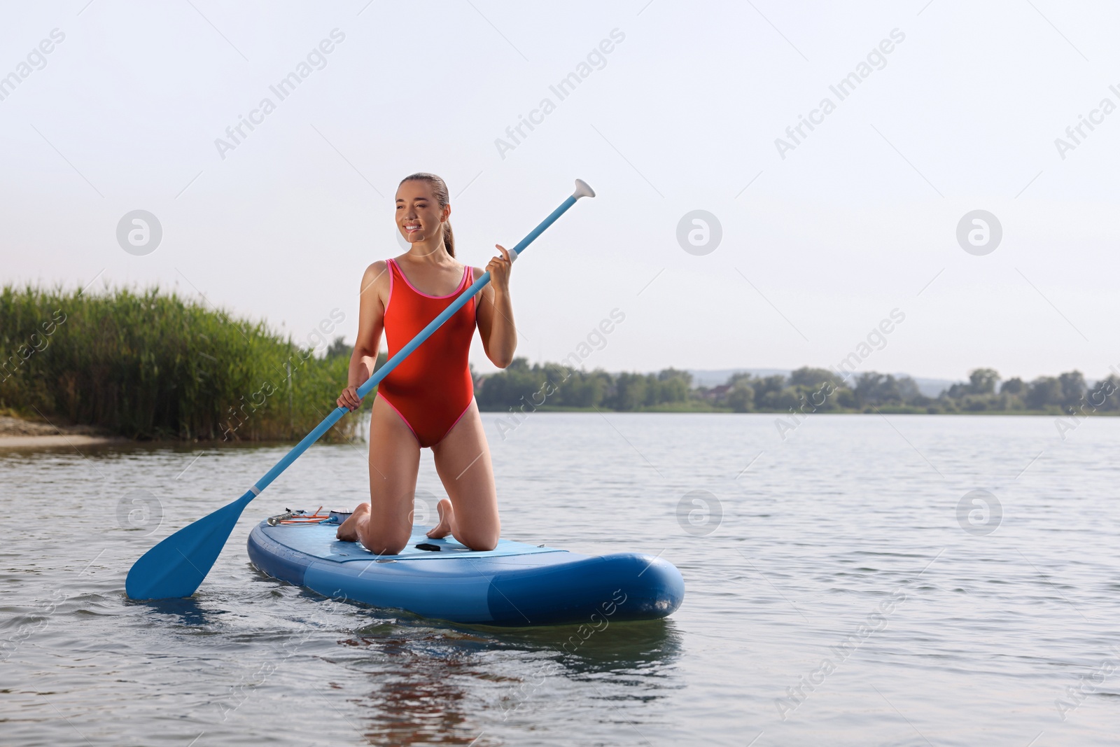 Photo of Woman paddle boarding on SUP board in sea, space for text