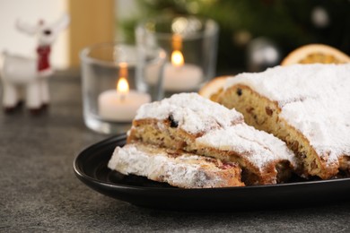 Traditional Christmas Stollen with icing sugar on grey table, closeup