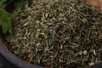 Photo of Dried aromatic parsley in bowl, closeup view