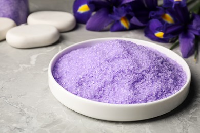Photo of Plate with purple sea salt on grey marble table, closeup