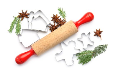 Photo of Cookie cutters, rolling pin, fir branches and anise stars on white background, top view