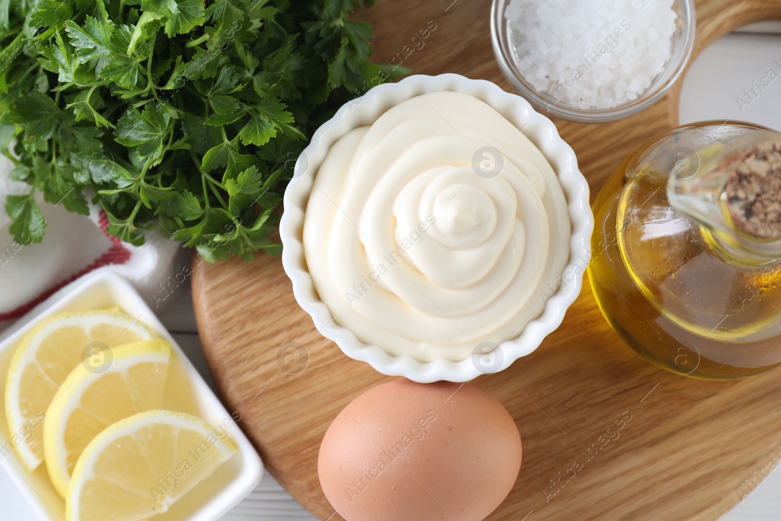 Photo of Fresh mayonnaise sauce in bowl and ingredients on table, flat lay