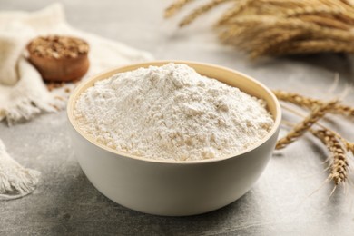 Photo of Bowl of flour on light grey table, closeup