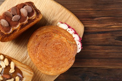 Photo of Tasty puff pastry. Round croissants on wooden table, top view. Space for text