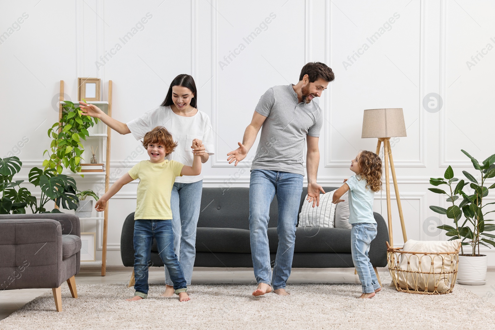 Photo of Happy family dancing and having fun in living room