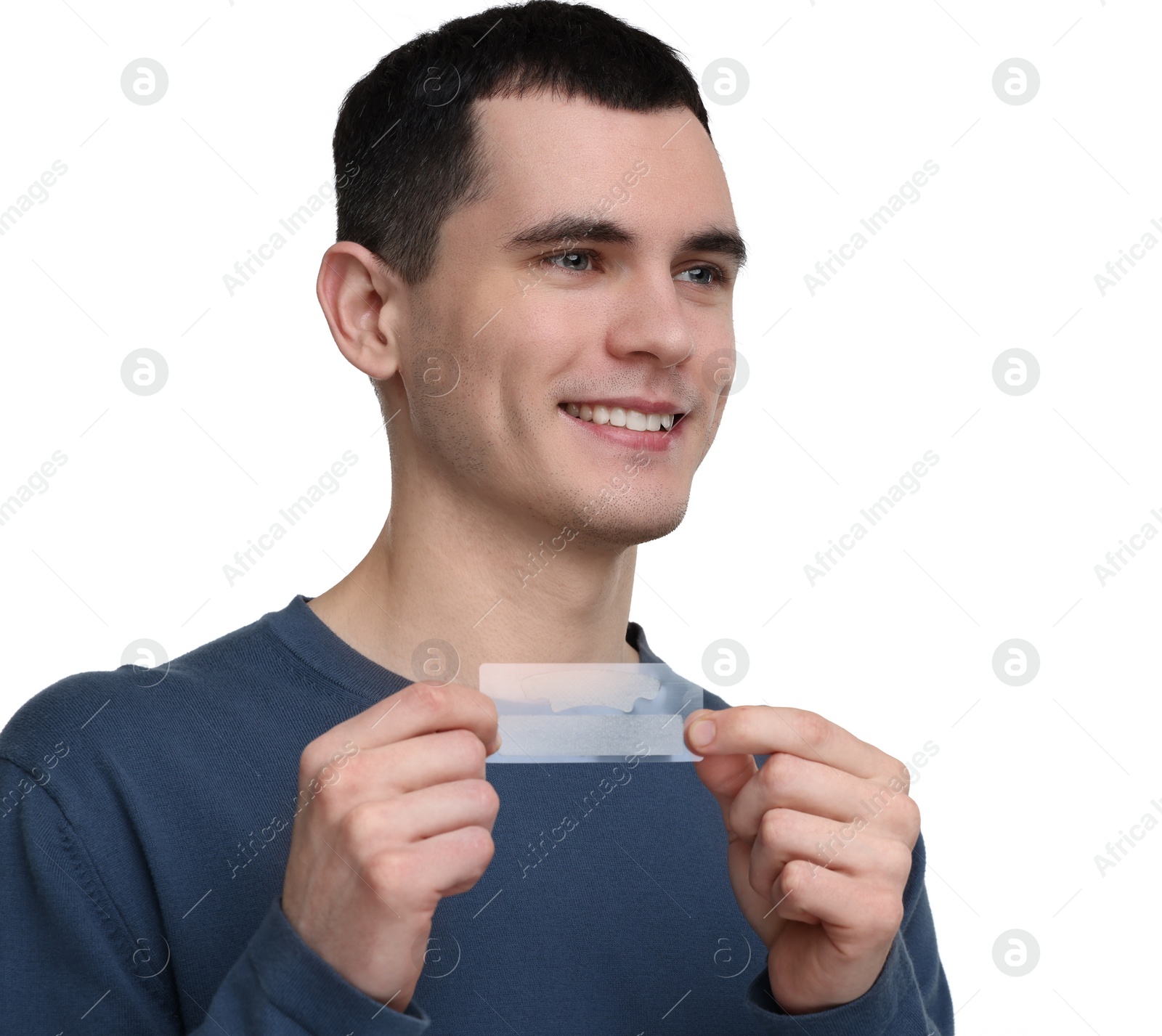 Photo of Young man with whitening strips on light background. Space for text