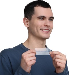 Young man with whitening strips on light background. Space for text