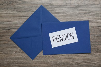 Photo of Card with word Pension and envelopes on wooden table, flat lay