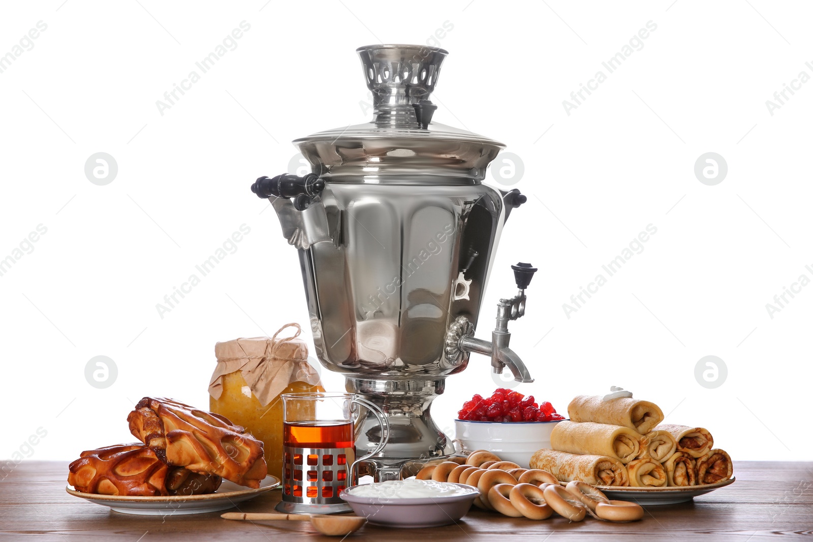 Photo of Traditional Russian samovar and treats on wooden table against white background