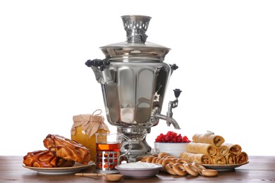 Traditional Russian samovar and treats on wooden table against white background