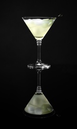Photo of Glass of delicious cucumber martini with ice on dark background
