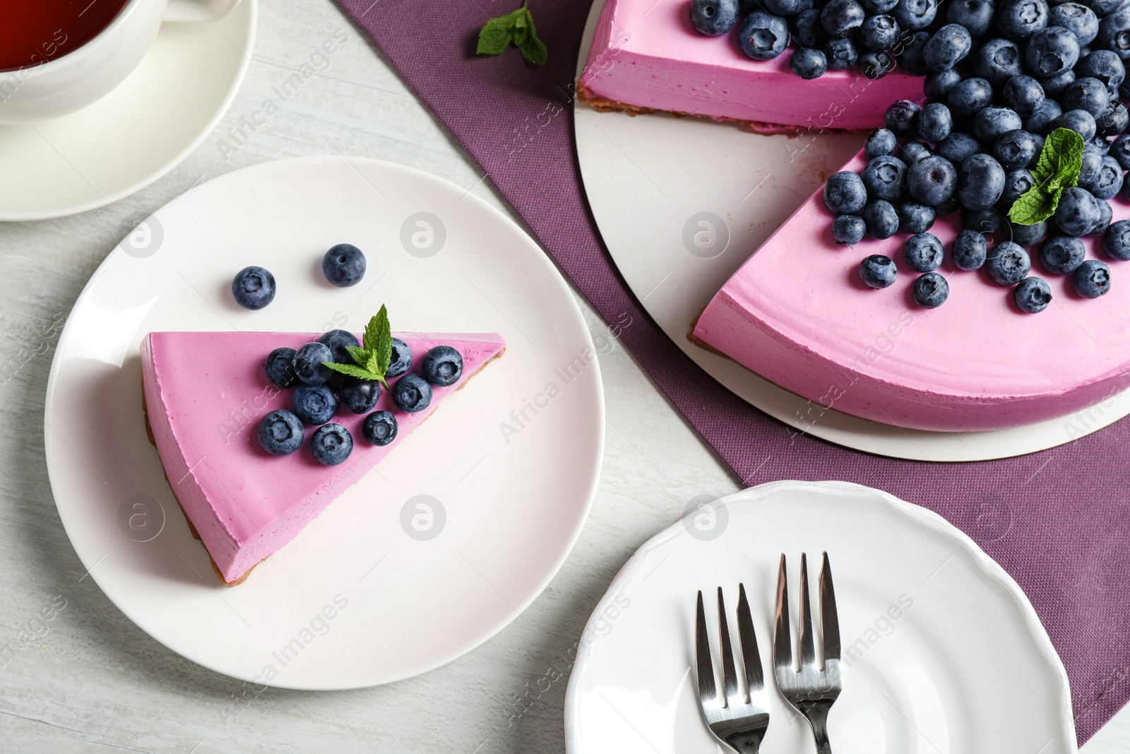 Photo of Flat lay composition of tasty blueberry cake on light table