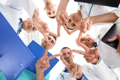 Photo of Group of doctors on light background, bottom view. Cardiology conference