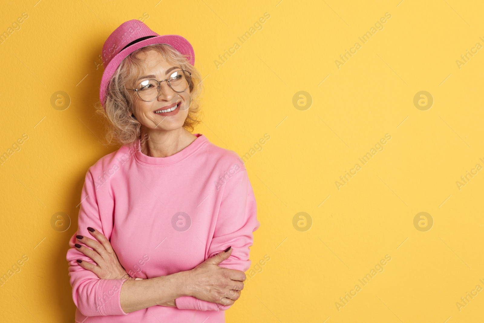 Photo of Portrait of mature woman in hipster outfit on color background. Space for text