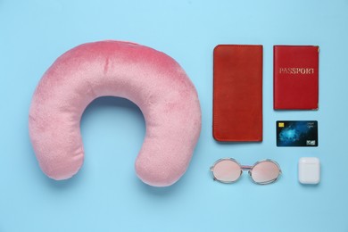 Photo of Flat lay composition with pink travel pillow on light blue background