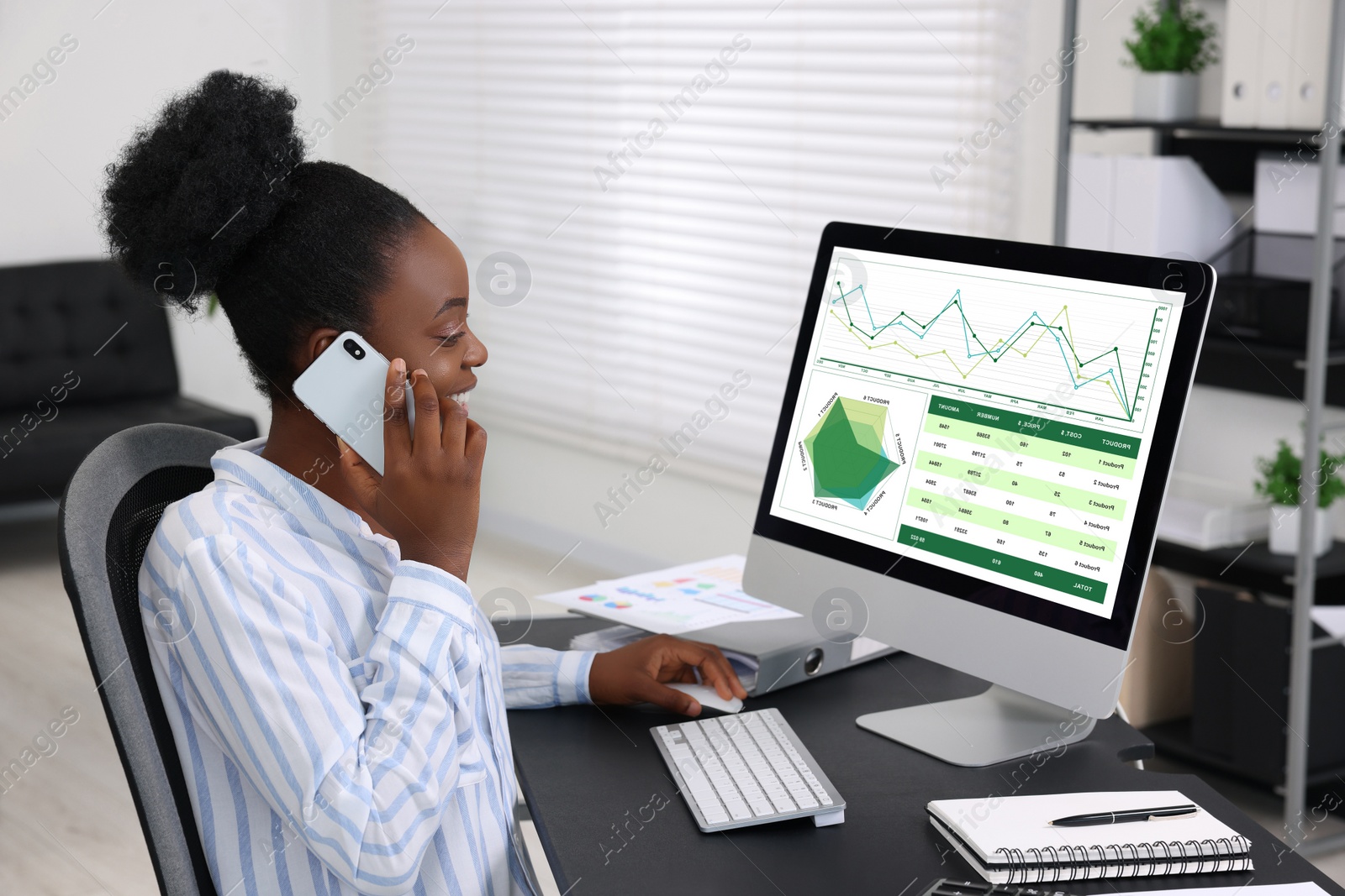 Photo of Professional accountant talking on phone and working at desk in office