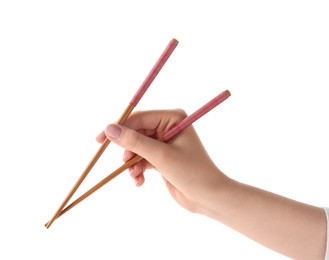 Photo of Woman holding pair of wooden chopsticks on white background, closeup