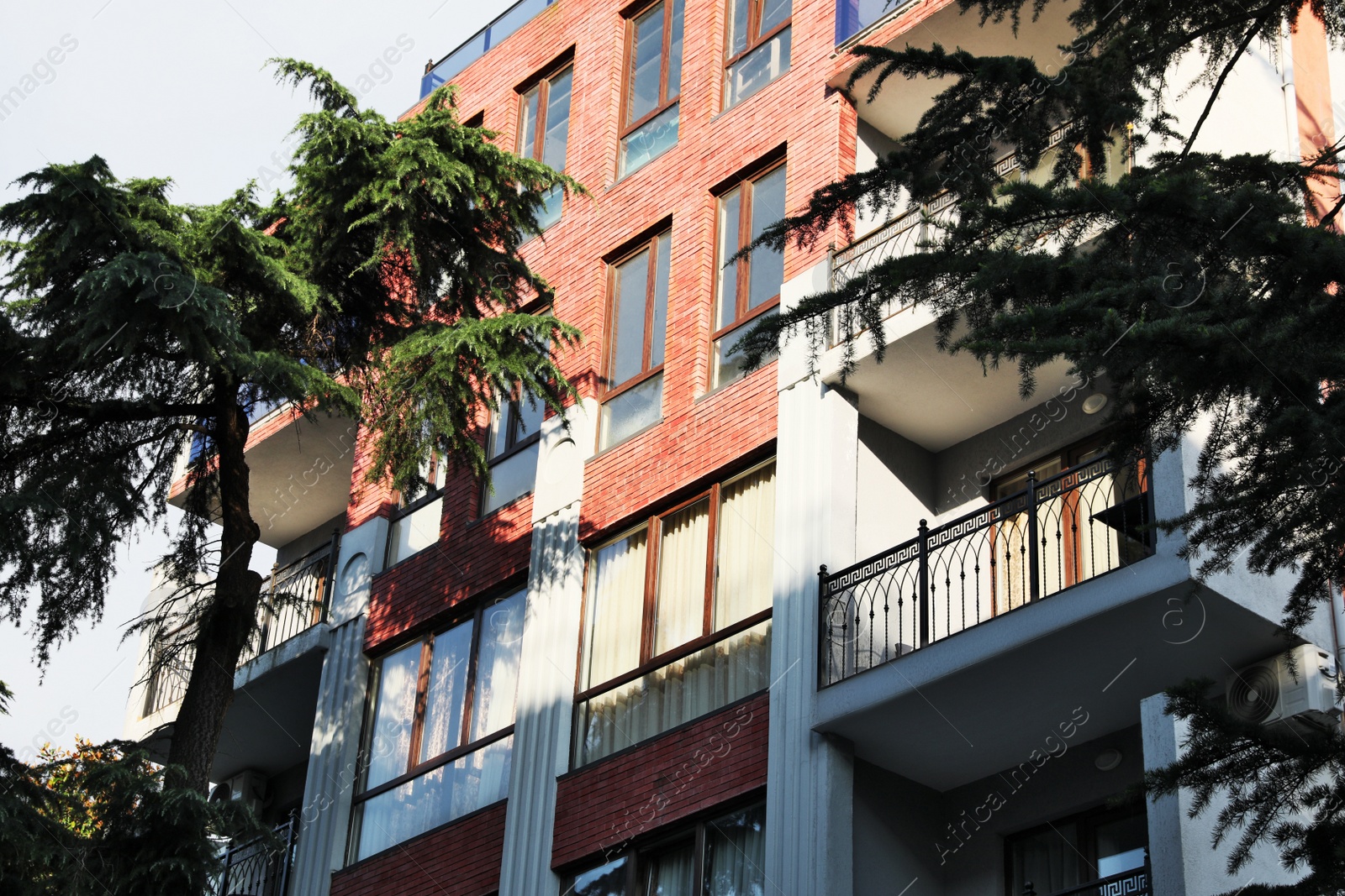 Photo of Exterior of beautiful residential building with balconies, low angle view