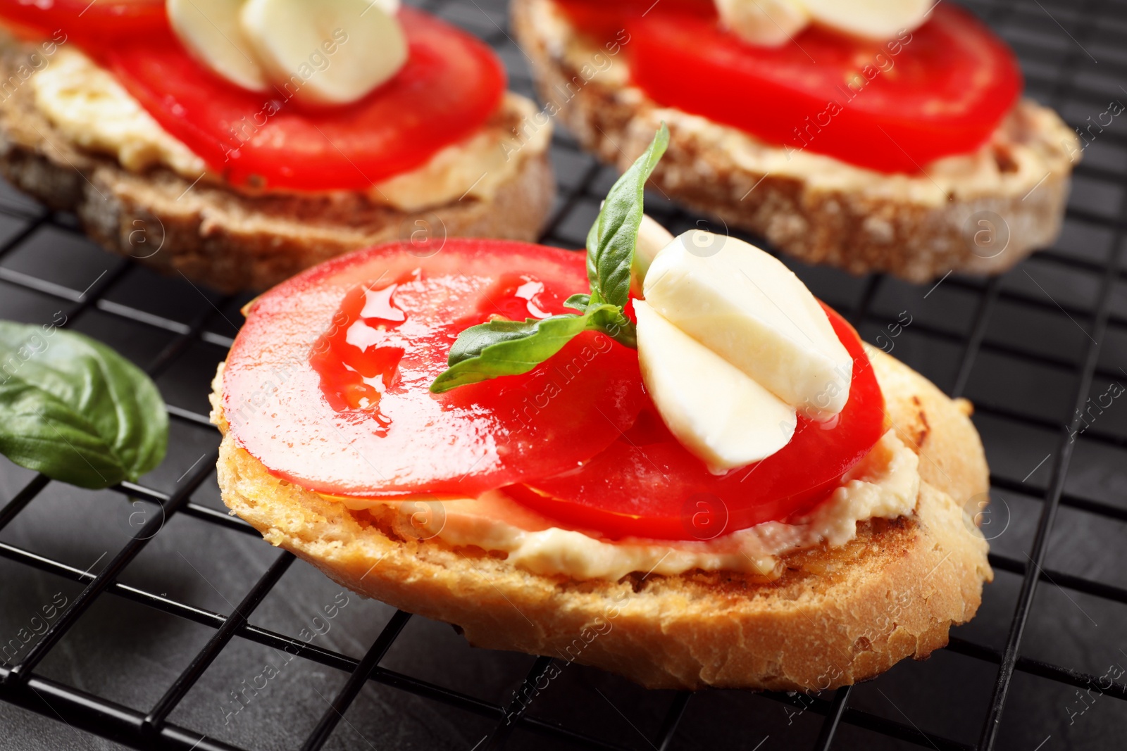 Photo of Tasty fresh tomato bruschettas on cooling rack