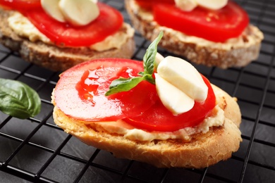 Photo of Tasty fresh tomato bruschettas on cooling rack