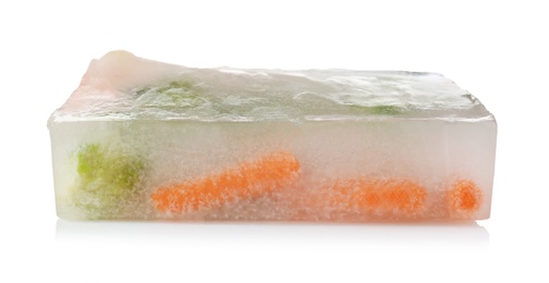 Photo of Fresh vegetables frozen in ice cube on white background