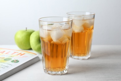 Two glasses of fresh apple juice on table