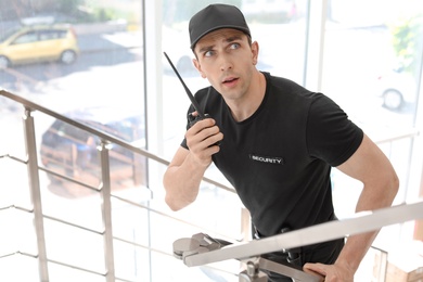 Male security guard with portable radio transmitter indoors