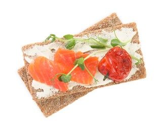 Photo of Fresh rye crispbreads with salmon, cream cheese and grilled tomato on white background, top view