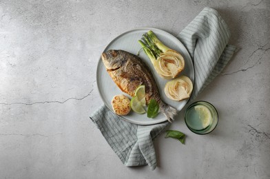 Delicious dorado fish with vegetables served on light grey table, flat lay. Space for text