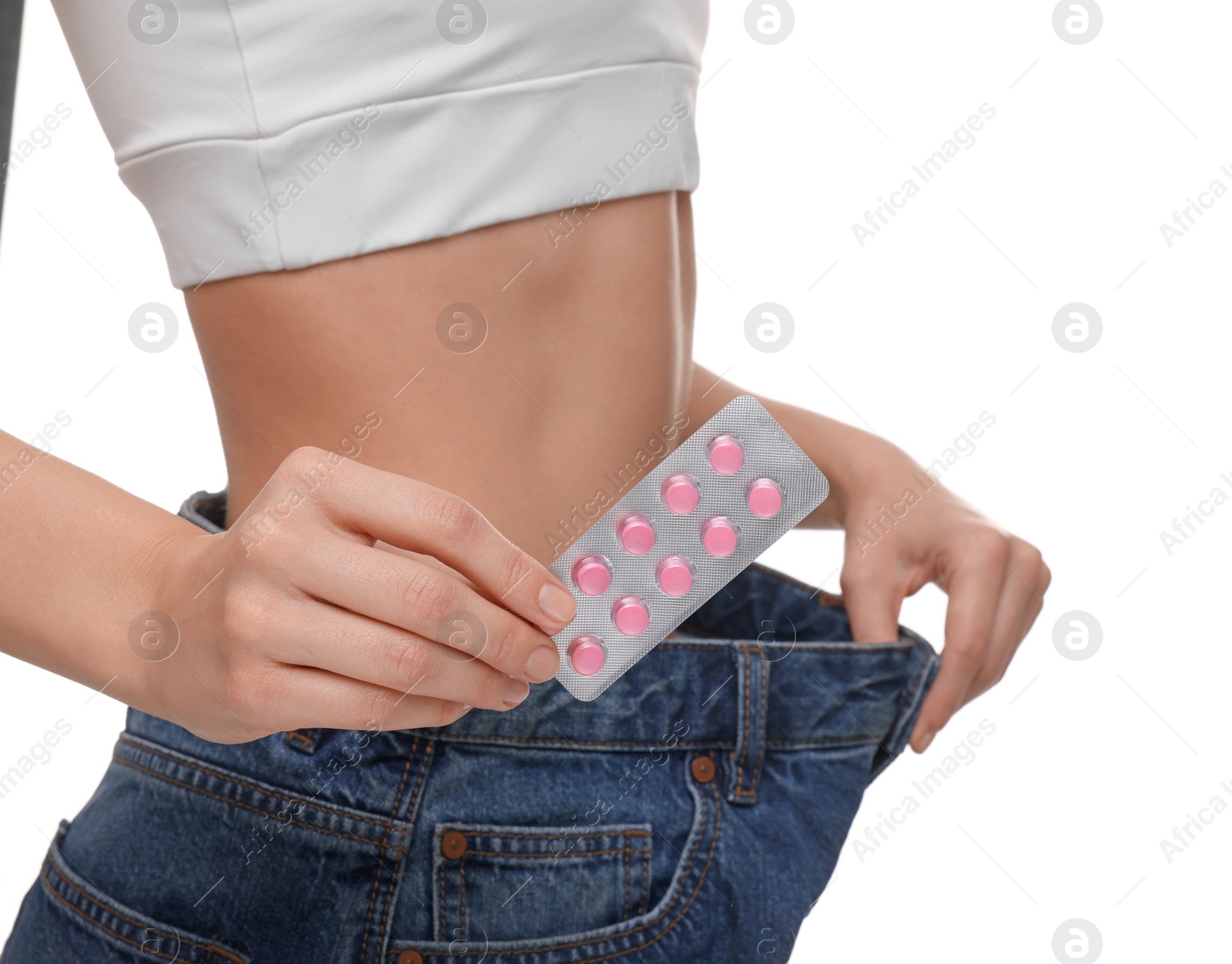Photo of Slim woman in big jeans with pills on white background, closeup. Weight loss
