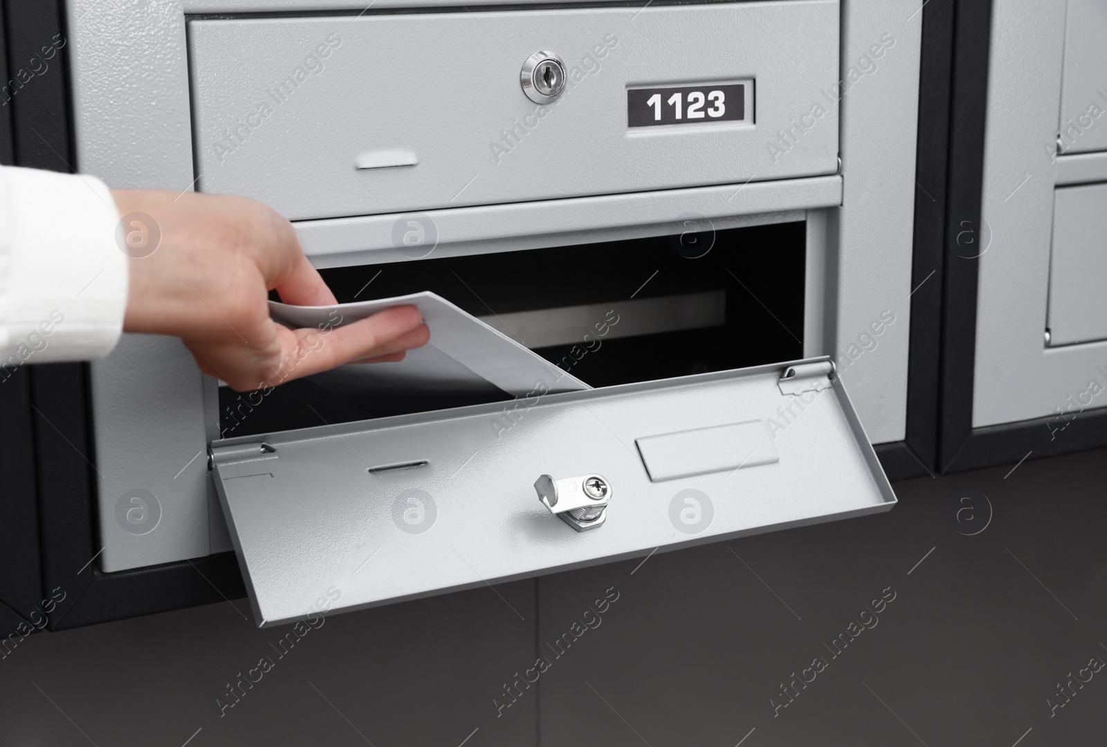 Photo of Woman taking envelopes out from mailbox indoors, closeup