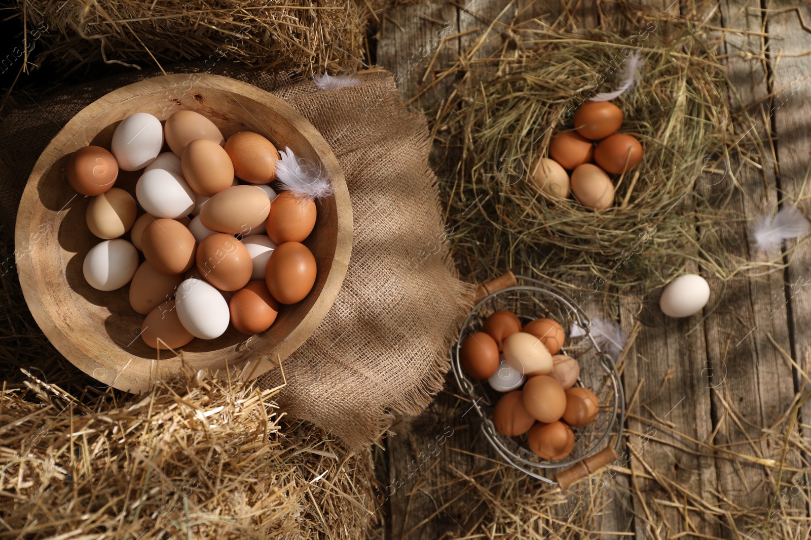 Photo of Fresh chicken eggs and dried straw in henhouse, flat lay