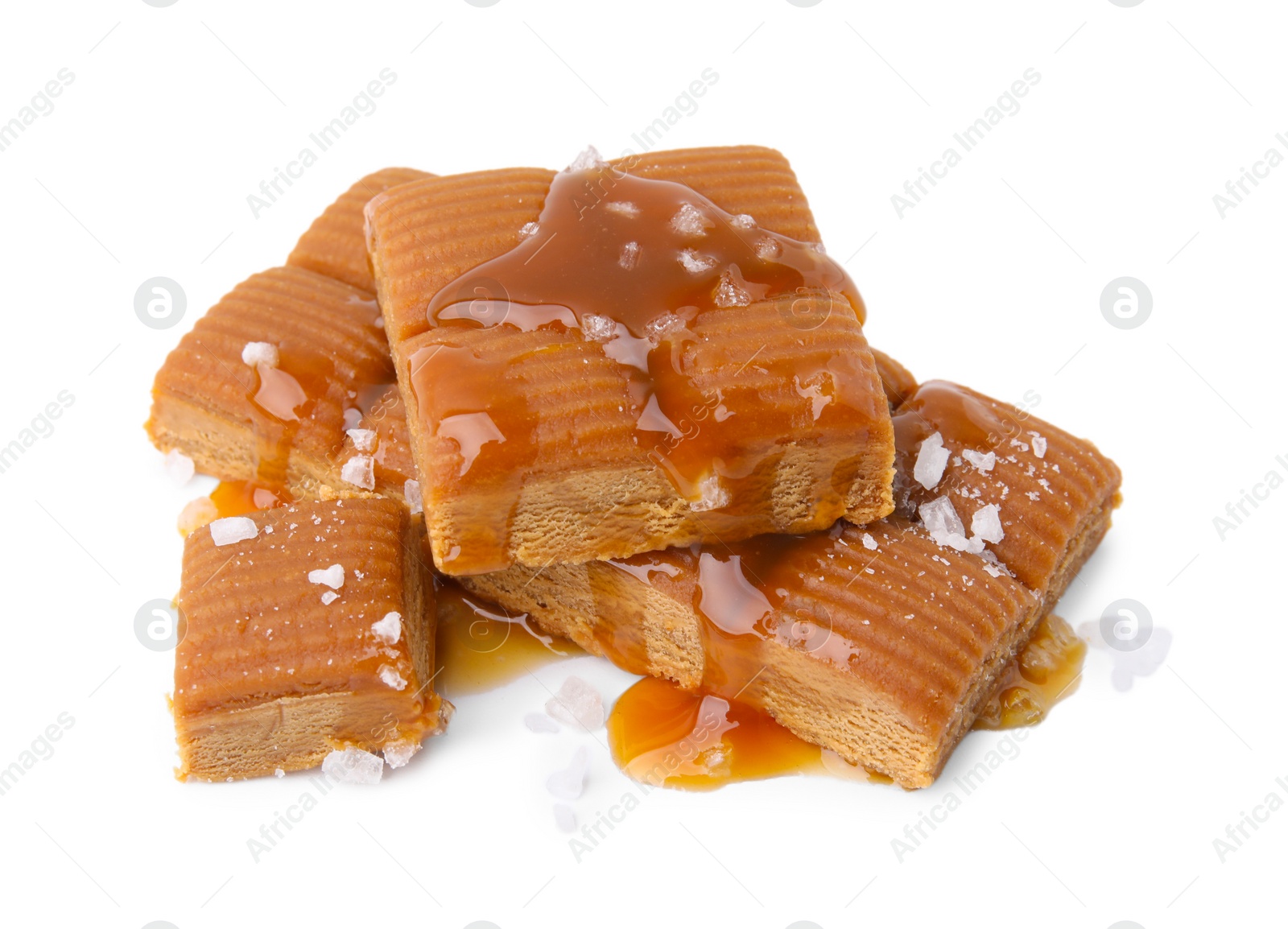 Photo of Yummy caramel candies and sea salt isolated on white