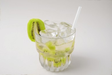 Photo of Glass of refreshing drink with kiwi on beige background, closeup