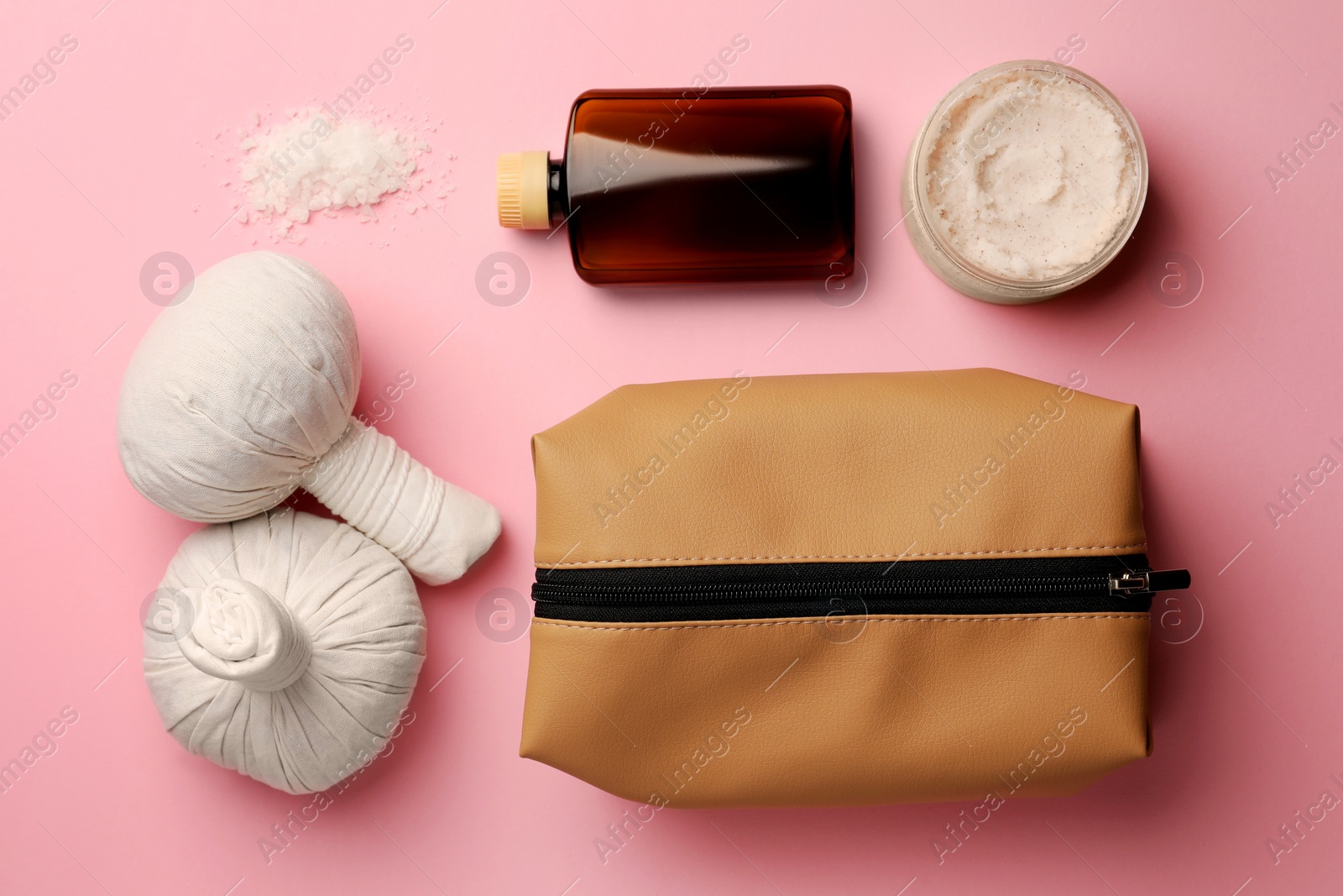 Photo of Preparation for spa. Flat lay composition with compact toiletry bag and cosmetic products on pink background