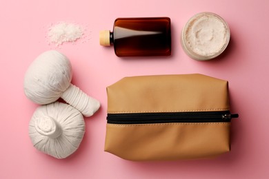 Preparation for spa. Flat lay composition with compact toiletry bag and cosmetic products on pink background