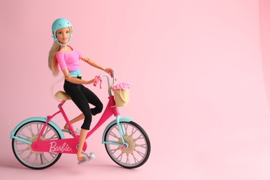Photo of Mykolaiv, Ukraine - September 2, 2023: Beautiful Barbie doll with bicycle on pink background, space for text