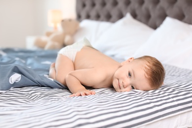 Photo of Adorable little baby lying on bed at home