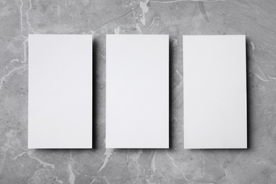 Photo of Empty sheets on grey marble table, flat lay. Mock up for design