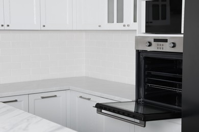 Photo of Modern oven and microwave in white clean kitchen