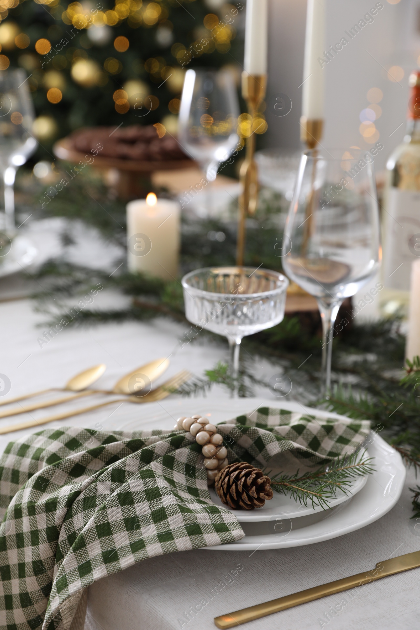 Photo of Christmas table setting with festive decor and dishware indoors