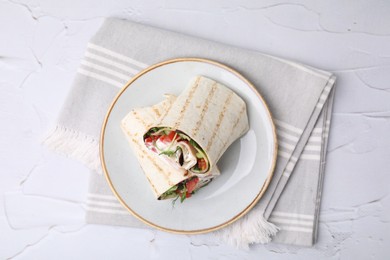 Photo of Delicious sandwich wraps with fresh vegetables on white textured table, top view