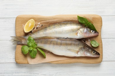 Photo of Fresh raw pike perches and ingredients on white wooden table, top view. River fish