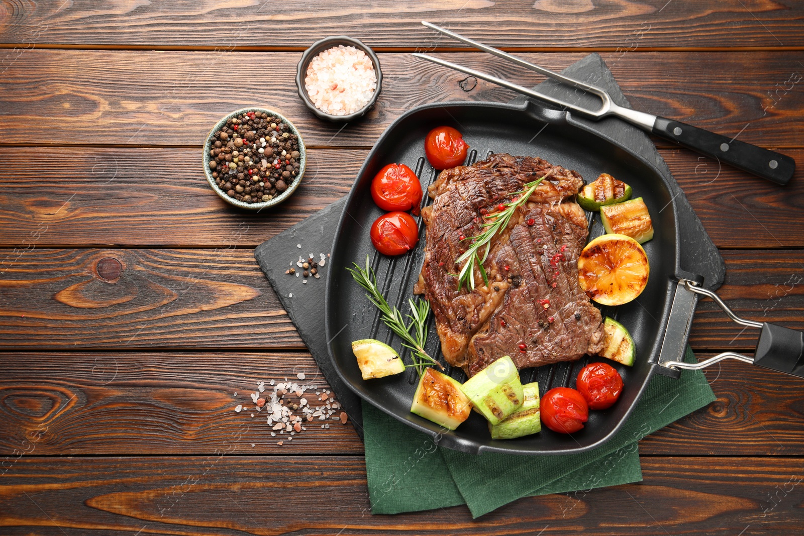 Photo of Delicious grilled beef steak and vegetables served on wooden table, flat lay. Space for text