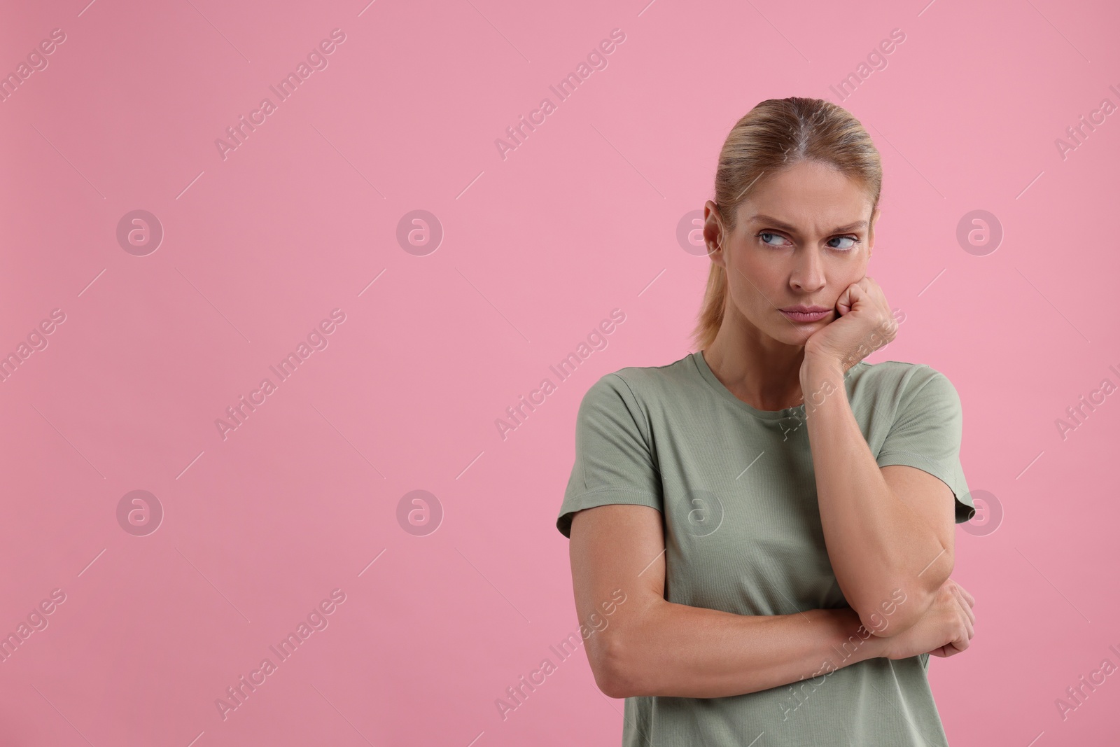 Photo of Resentful woman on pink background. Space for text